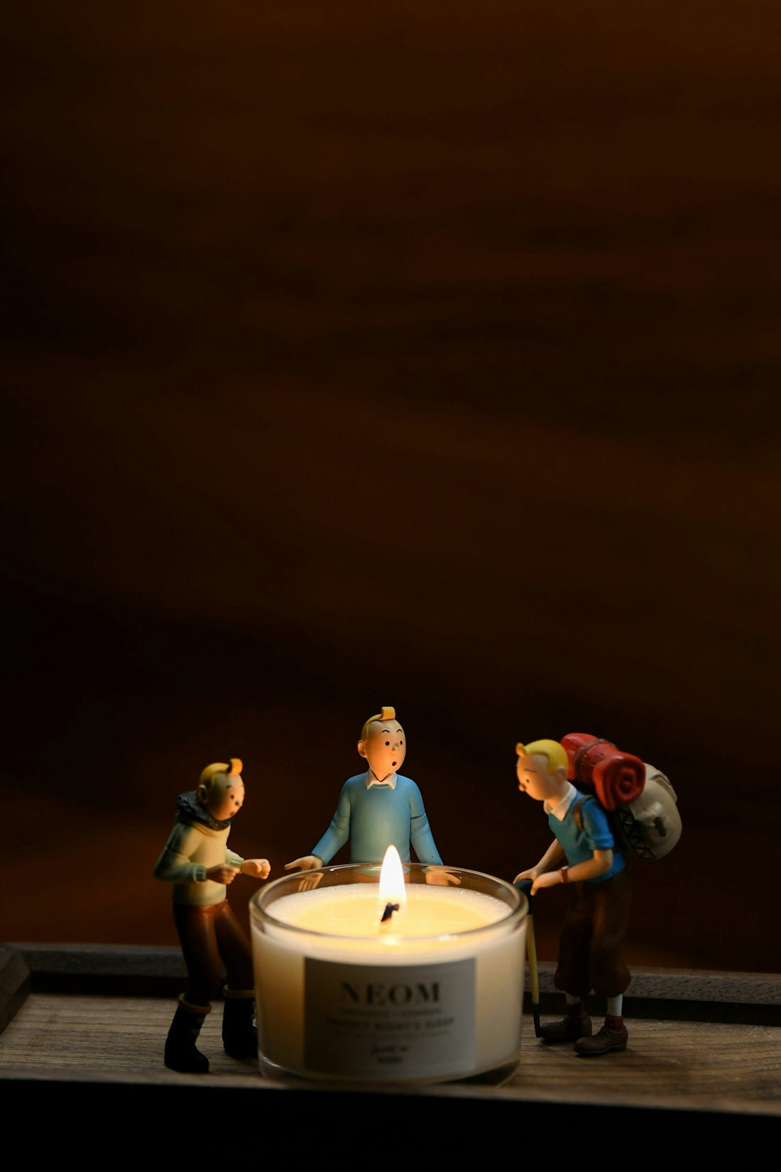 a candle with three figurines around it