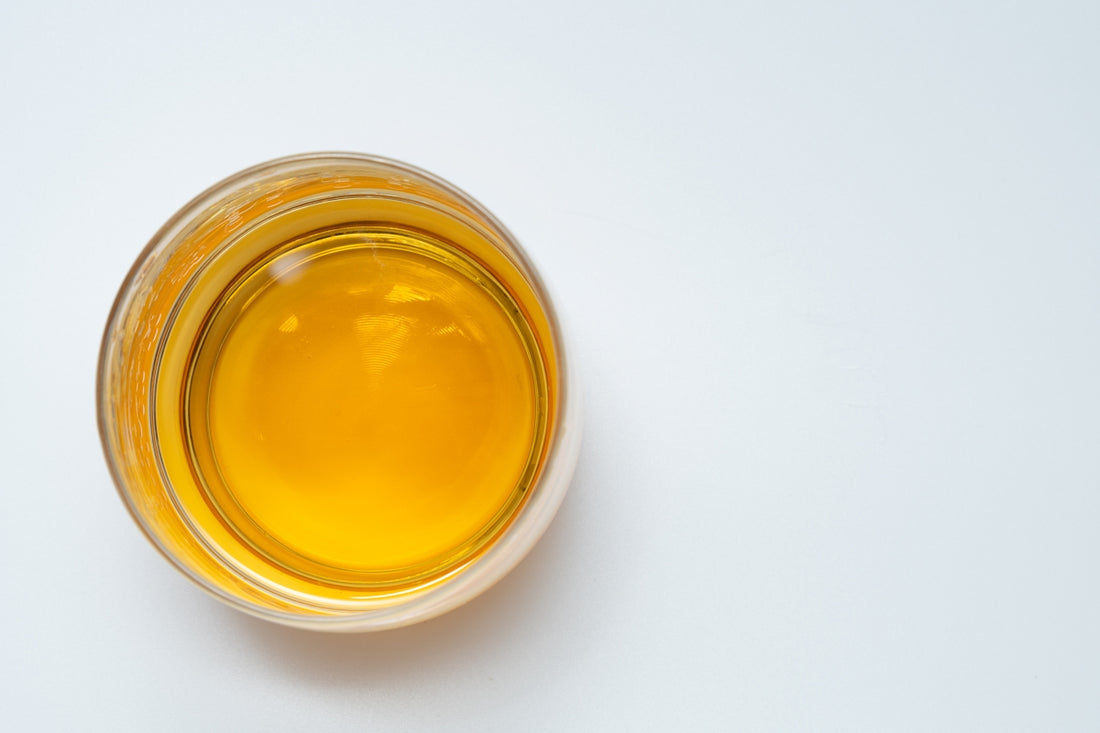 a glass filled with liquid sitting on top of a white table