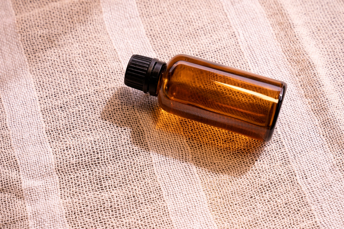 a bottle of essential oil sitting on a cloth