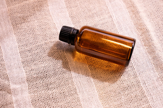 a bottle of essential oil sitting on a cloth