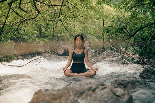 A woman sitting in a river meditating